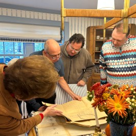 a group of people standing on top of a cutting board with a cake