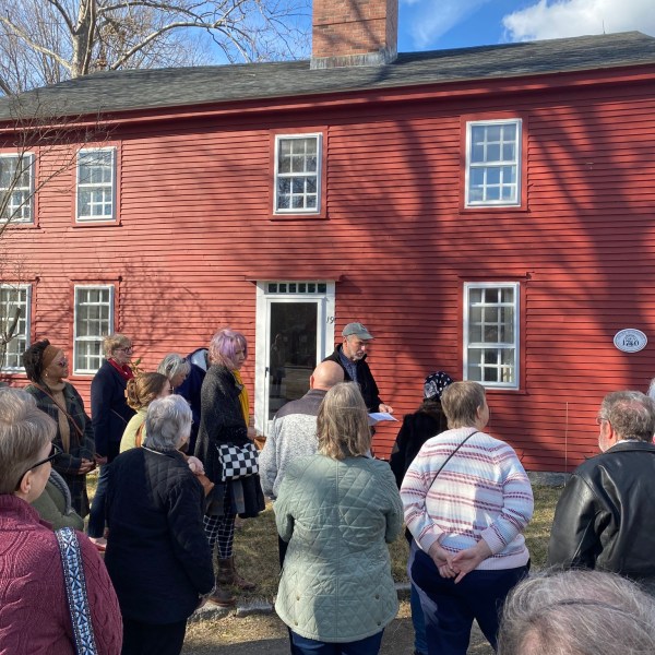 a group of people standing in front of a brick building