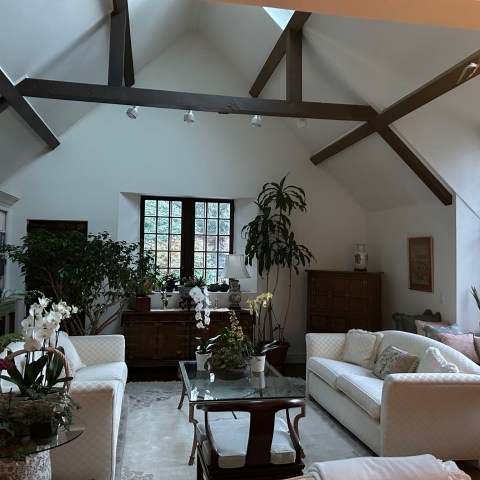 a living room filled with furniture and vase of flowers on a table