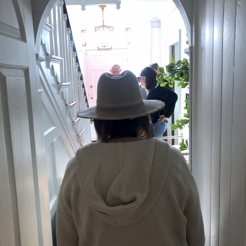 a man wearing a hat in front of a window