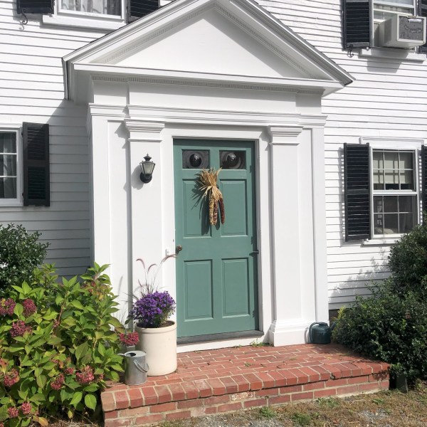a house with bushes in front of a brick building