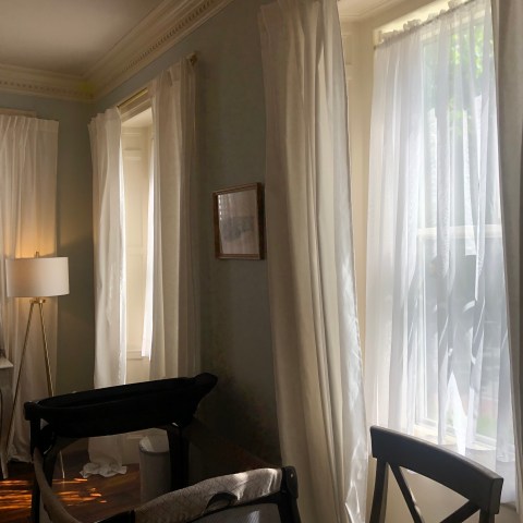 a bedroom with a bed and a chair in front of a window