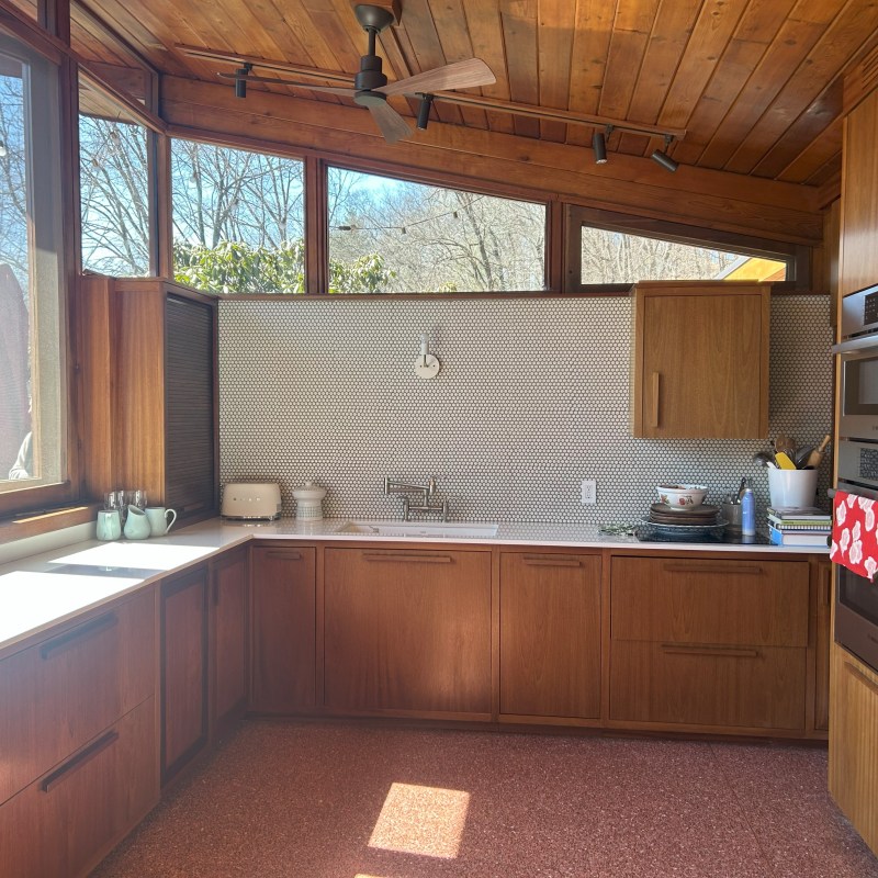 a kitchen with wooden cabinets and a large window