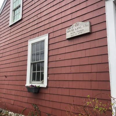 a house with bushes in front of a brick building