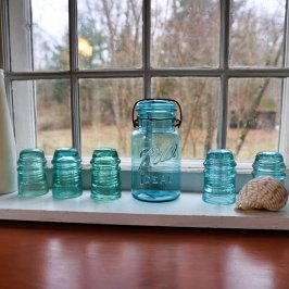 a glass bottle next to a window