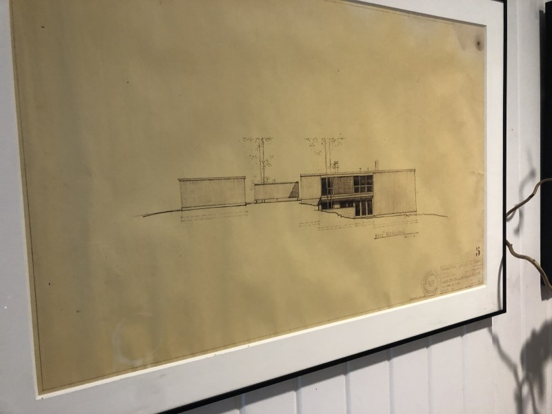 Framed architectural drawing of a modernist building on yellowed paper.